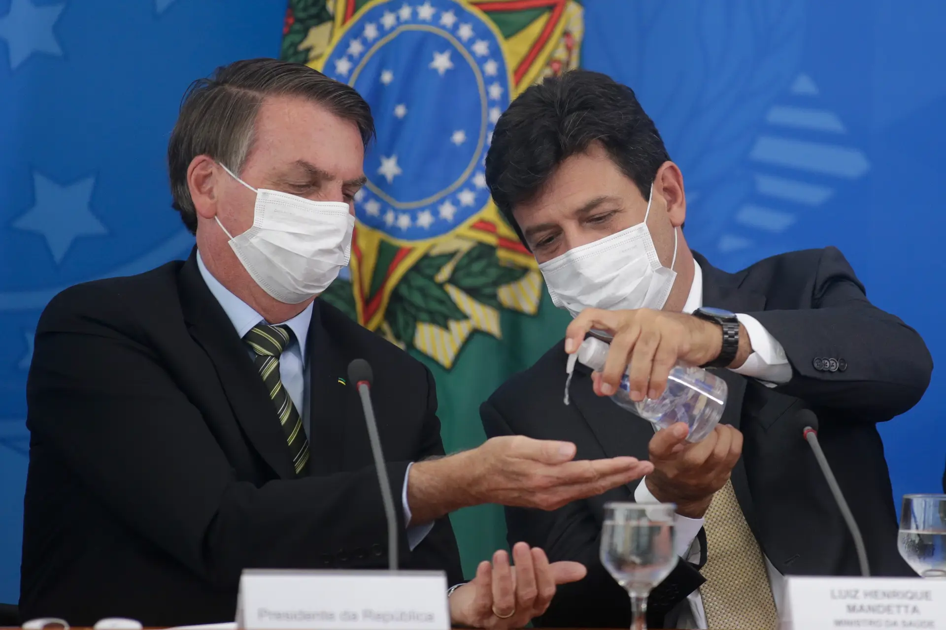 Ministro da Saúde brasileiro, Luiz Henrique Mandetta, acompanhado do presidente do país.
