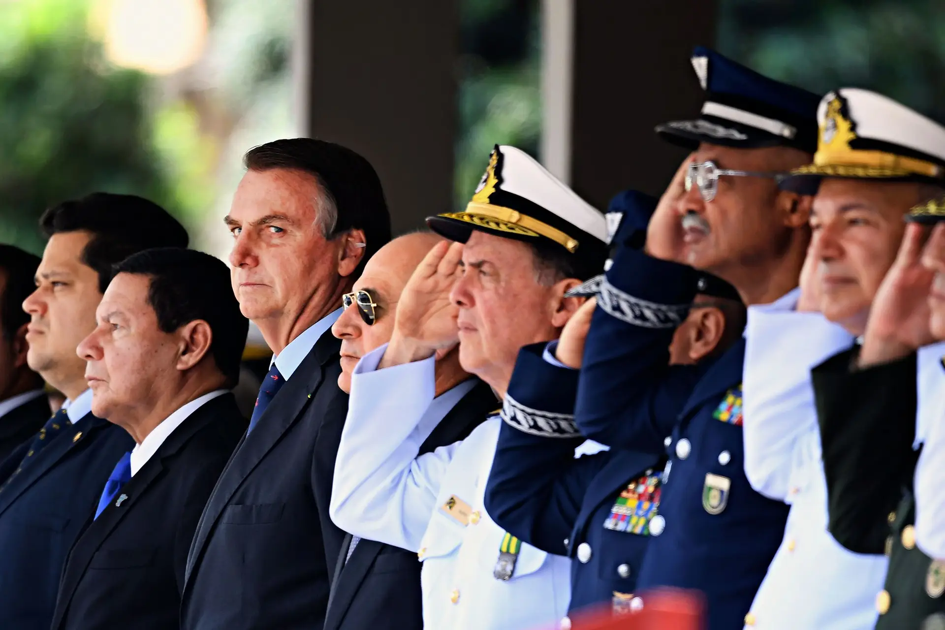 O Presidente Jair Bolsonaro e o seu vice, Hamilton Mourão (terceiro e segundo a contar da esq.), numa cerimónia militar em Brasília