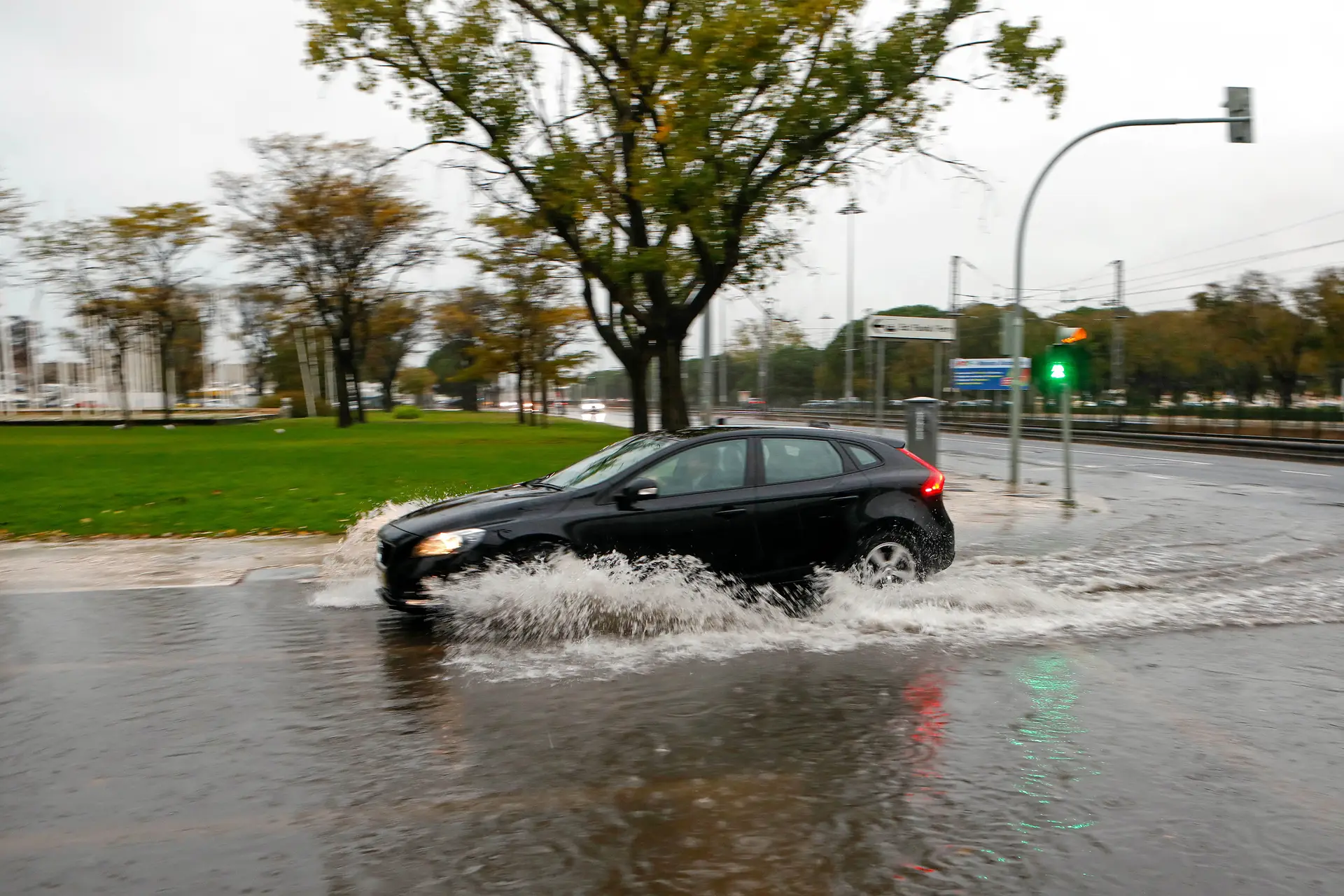 Um automóvel passa por uma estrada alagada por fortes chuvas, na zona de Belém, em Lisboa