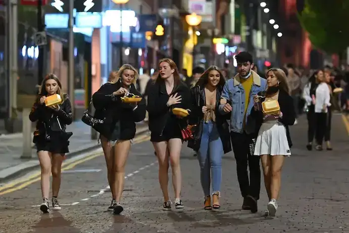 Jovens a conviver no centro da cidade de Liverpool, na noite de 13 de outubro de 2020, no dia anterior a serem impostas novas restrições devido à pandemia de covid-19