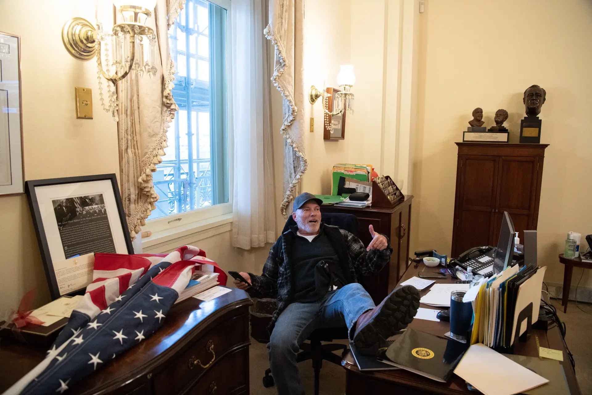 Richard “Bigo” Barnett, um dos invasores do Capitólio, sentado na cadeira de nancy Pelosi, numa imagem que percorreu o mundo