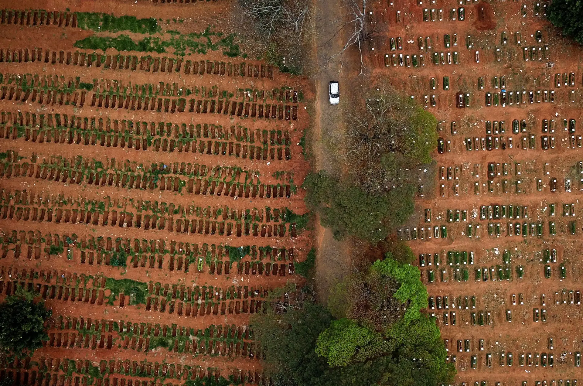 O número de mortos, entretanto, vai aumentando, repetindo-se imagens como esta, de vistas aéreas de cemitérios, um pouco por todo o mundo. Este é o de Vila Formosa, na região de São Paulo, Brasil,