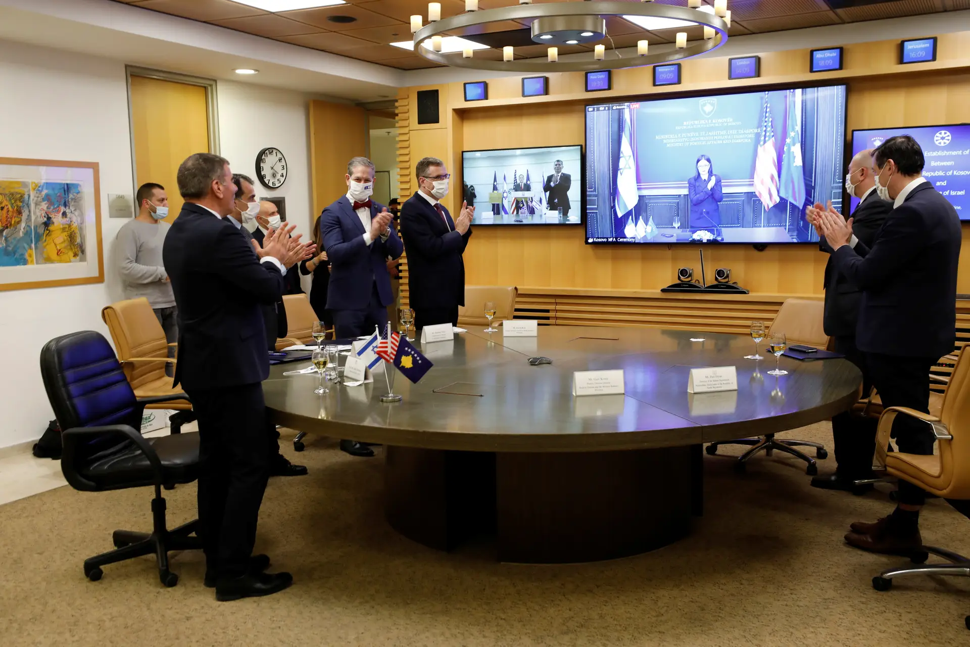 De frente para o ecrã, Gabi Ashkenazi, o ministro dos Negócios Estrangeiros de Israel, está em Jerusalém. A homóloga kosovar, Meliza Haradinaj-Stublla (no ecrã), está em Pristina