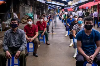 Vendedores e trabalhadores do mercado Long Bien, em Hanói, aguardam de forma disciplinada a sua vez para serem testados à covid-19