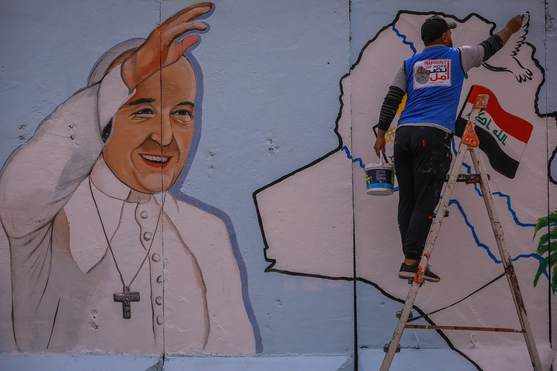 Um mural de boas vindas ao Papa Francisco é ultimado, numa parede que circunda a Igreja da Nossa Senhora da Salvação, em Bagdade
