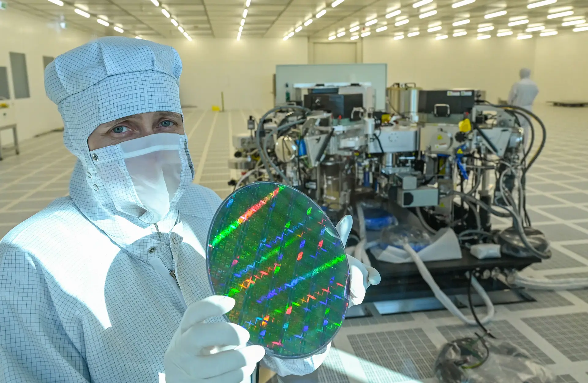 Uma funcionária do Leibniz Institute for Innovative Microelectronics, em Frankfurt, mostra uma wafer de mais de 20cm para microchips, em março de 2021