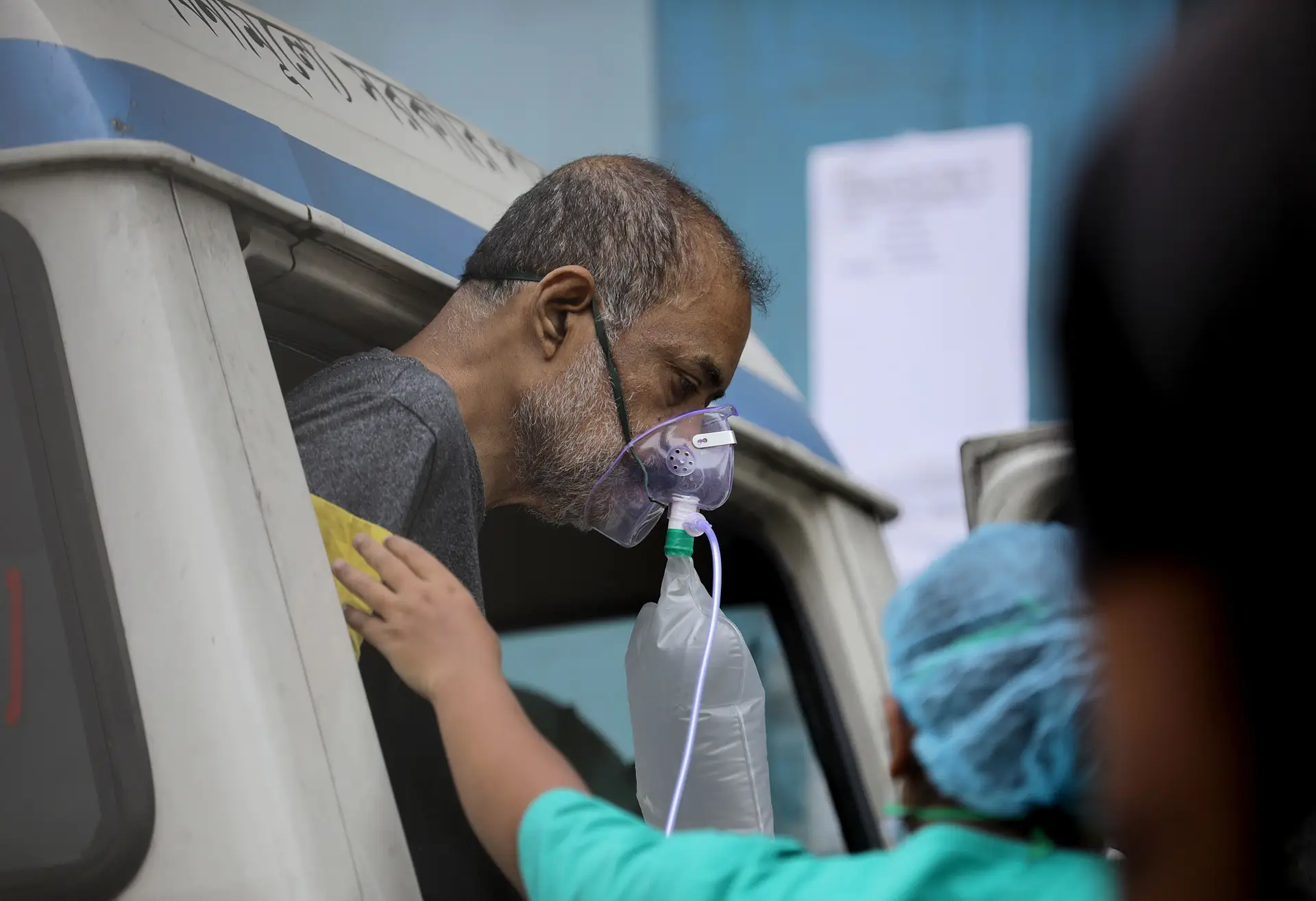 Um paciente é socorrido à porta do Hospital de Calcutá