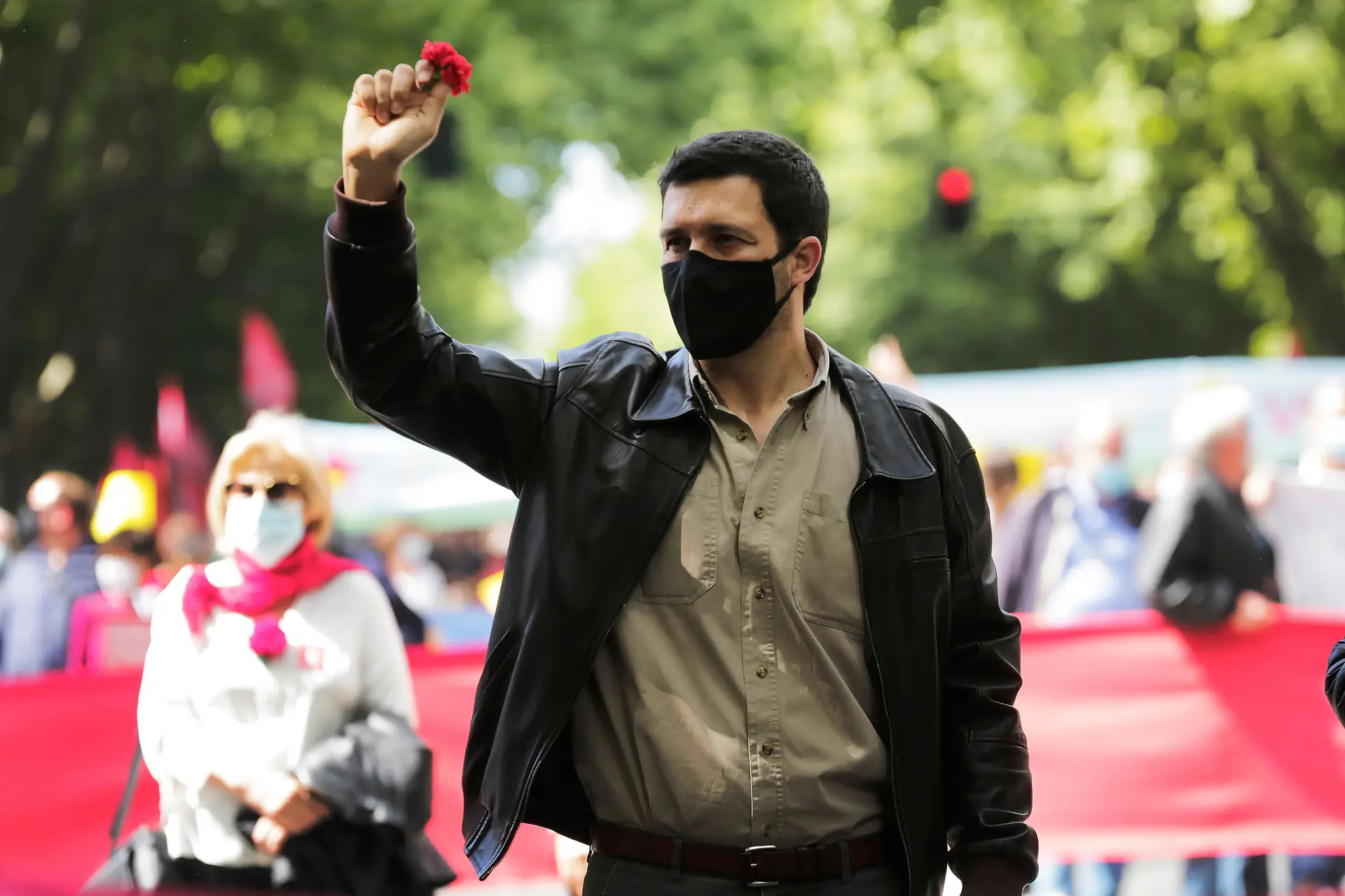 O comunista João Ferreira, sem gravata posta mas com a máscara sempre colocada, vestido de forma casual, fazendo do cravo vermelho o principal adereço