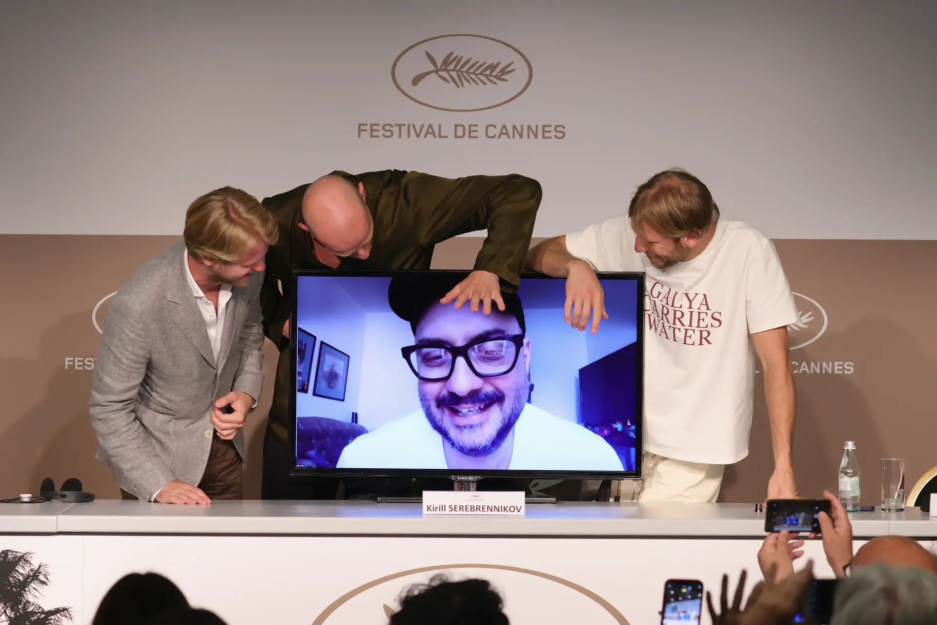 O realizador (no ecrã) saudado à distância no festival de Cannes, durante a conferência de imprensa de apresentação do seu filme "A gripe de Petrov"