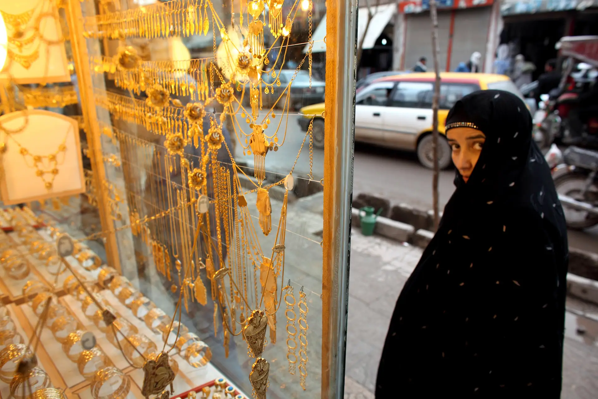 Uma mulher afegã passa pela monstra de uma joalharia em Herat, a terceira maior cidade do país