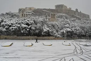 GRÉCIA. Um passeio solitário num ‘tapate’ de neve, no sopé da Acrópole, em Atenas FOTO: Louisa Gouliamaki / AFP / Getty Images