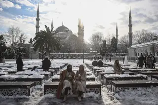 TURQUIA. O gelo não impede uma pausa descontraída, na Praça Sultanahmet, em Istambul FOTO: Arif Hudaverdi Yaman / Anadolu Agency / Getty Images
