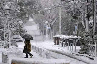 GRÉCIA. Um guarda-chuva que protege em dias de neve também FOTO: Aris Messinis / AFP / Getty Images