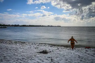 GRÉCIA. Indiferente à temperatura ambiente e à “areia gélida”, esta grega foi à água FOTO: Aris Messinis / AFP / Getty Images