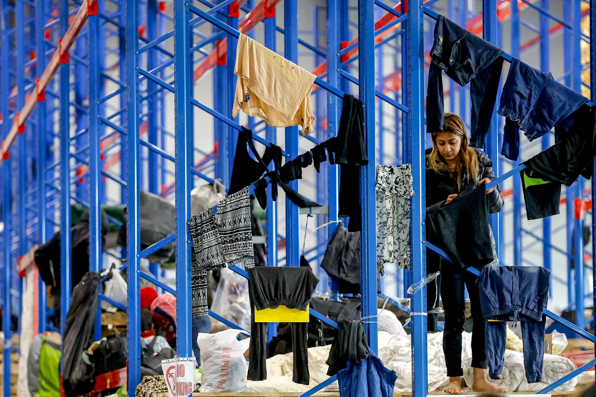 Uma migrante trata da roupa, num centro de acolhimento disponibilizado pelo Governo da Bielorrússia, próximo da fronteira com a Polónia FOTO: Sefa Karacan / Anadolu Agency / Getty Images
