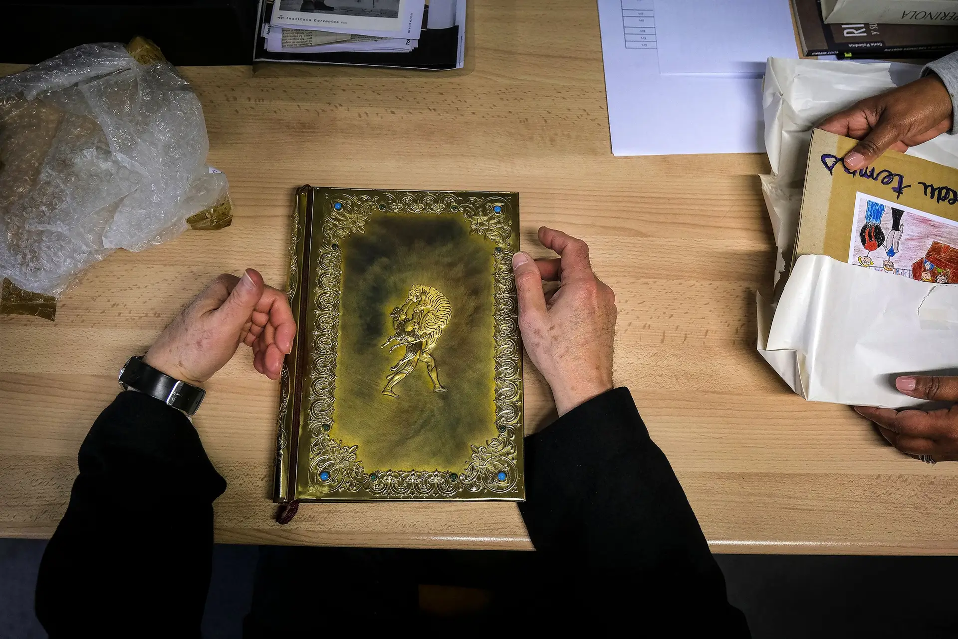 style="color:#666633">RARIDADES No meio dos 40 mil livros da biblioteca escondem-se objetos únicos, como uma Bíblia alemã manuscrita de 1300. Ou como um volume (na foto) com capa metálica oferecido a Manguel pelo embaixador da Geórgia na Argentina e que contém a epopeia clássica georgiana traduzida para inglês