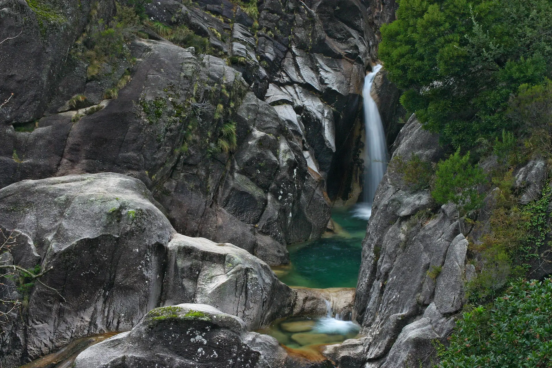Cascata do Arado: uma exuberante queda de água entre rochas imponentes e o verde da serra