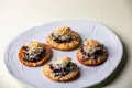 Tostada de cebola roxa, passas, queijo de São Jorge e avelãs