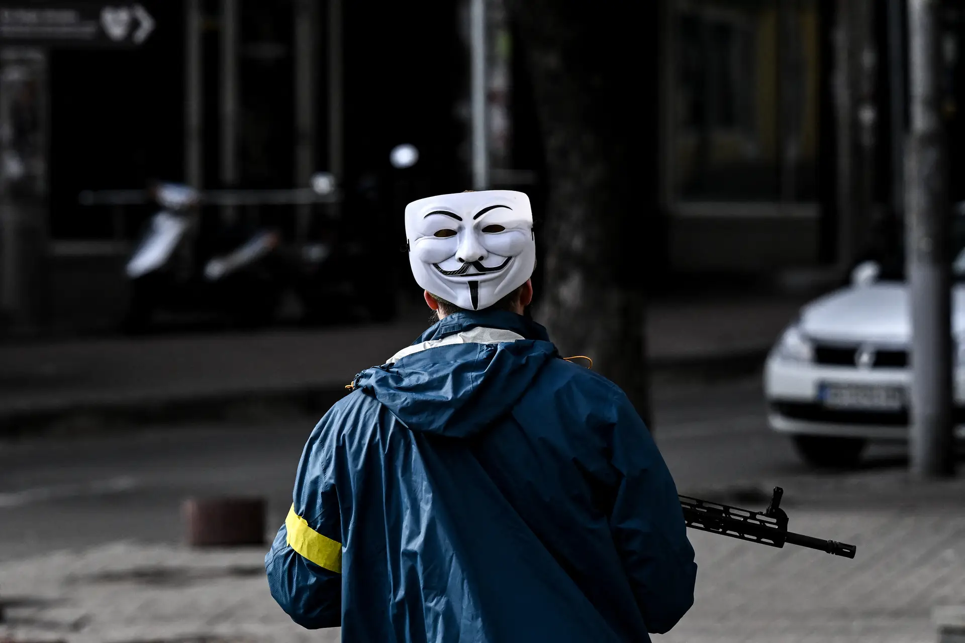A ironia faz parte da guerra. Aqui um elemento das forças de defesa ucranianas usando uma máscara dos Anonymous na nuca