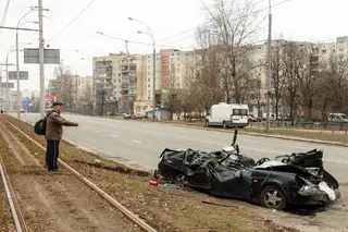 Um homem aponta para o veículo destruído de um sabotador russo que foi apanhado em Kiev