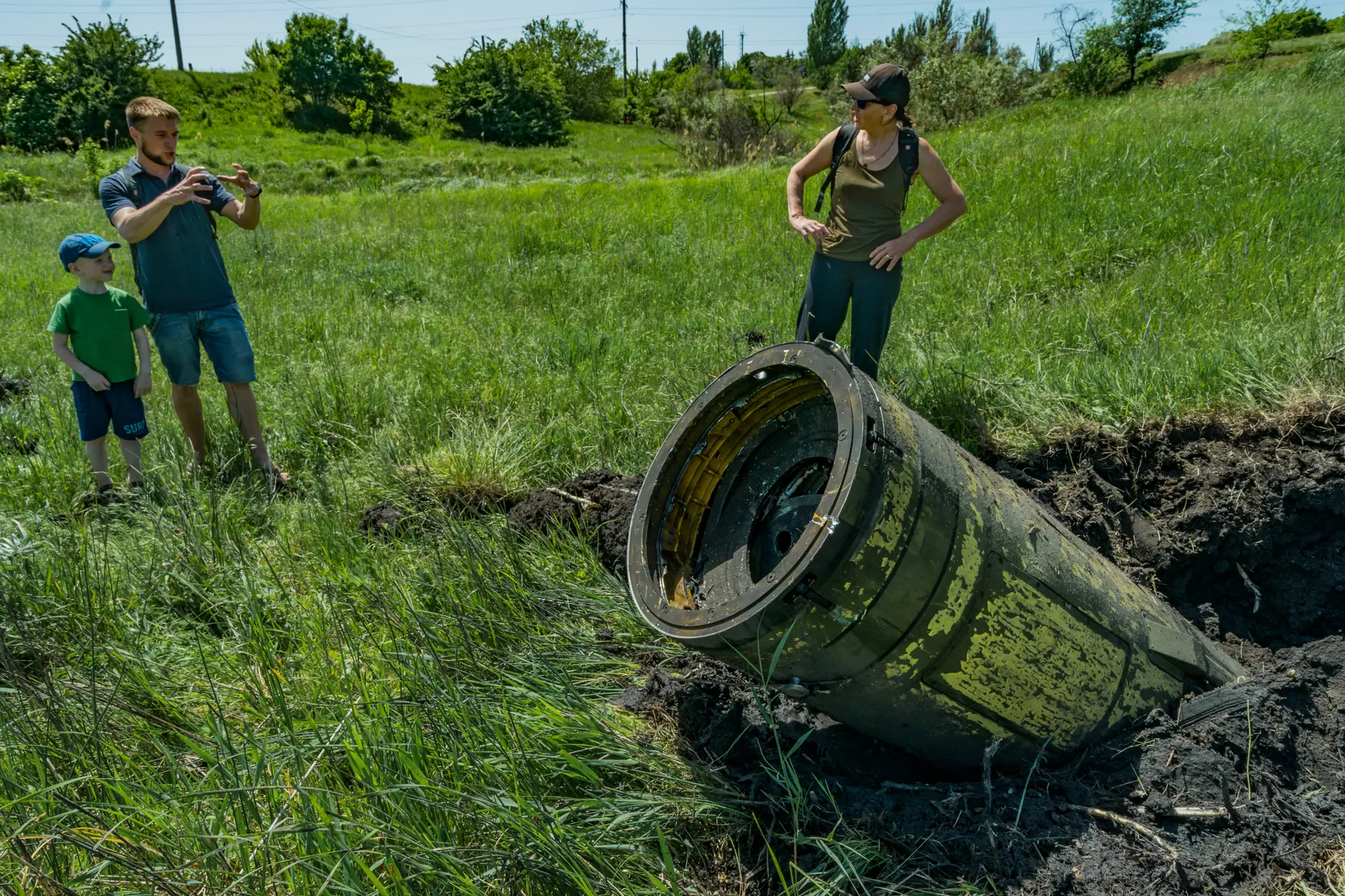 Civis observam os restos de um míssil Tochka russo na região ucraniana de Donbas. Moscovo acusa Kiev de utilizar projéteis idênticos, mas com munições ilegais 