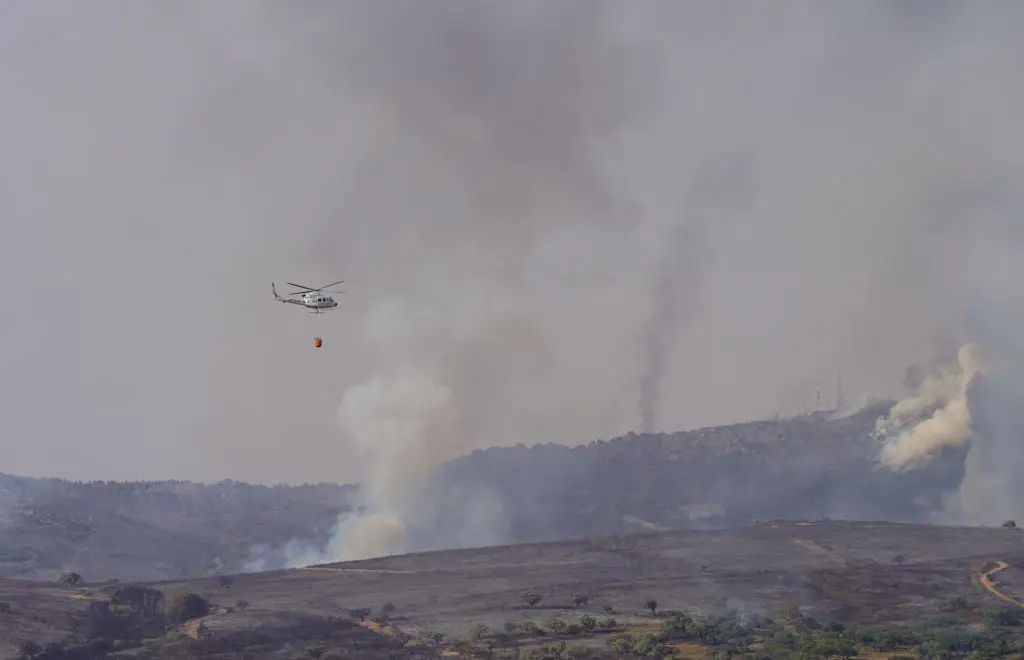 Um helicóptero deita água num incêndio florestal na região espanhola de Las Hurdes, na Extremadura. Cerca de 300 pessoas foram evacuadas na segunda-feira de cinco cidades desta região, enquanto os bombeiros lutavam para extinguir um incêndio "complicado selvagem"