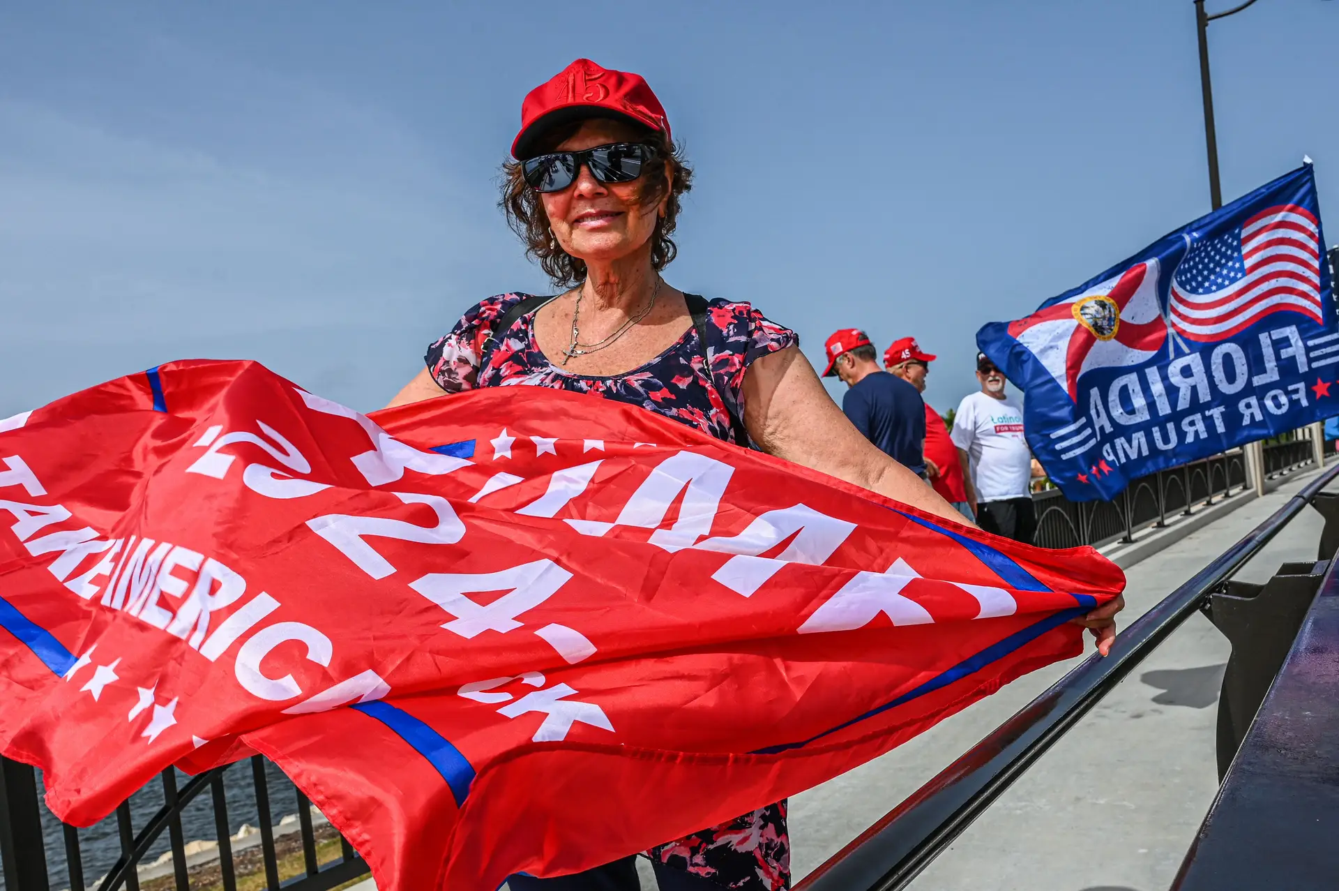 Uma apoiante de Trump com uma bandeira a mostrar que deseja que o ex-Presidente volte a concorrer