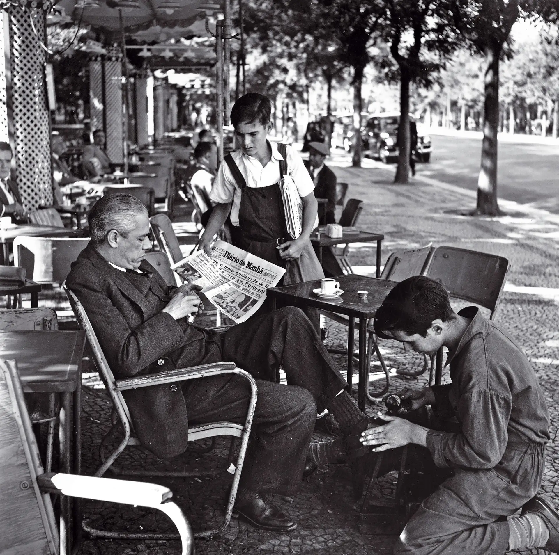 Cena de rua de Lisboa no início dos anos 50: os jovens ardina e engraxador servindo um cavalheiro de classe média