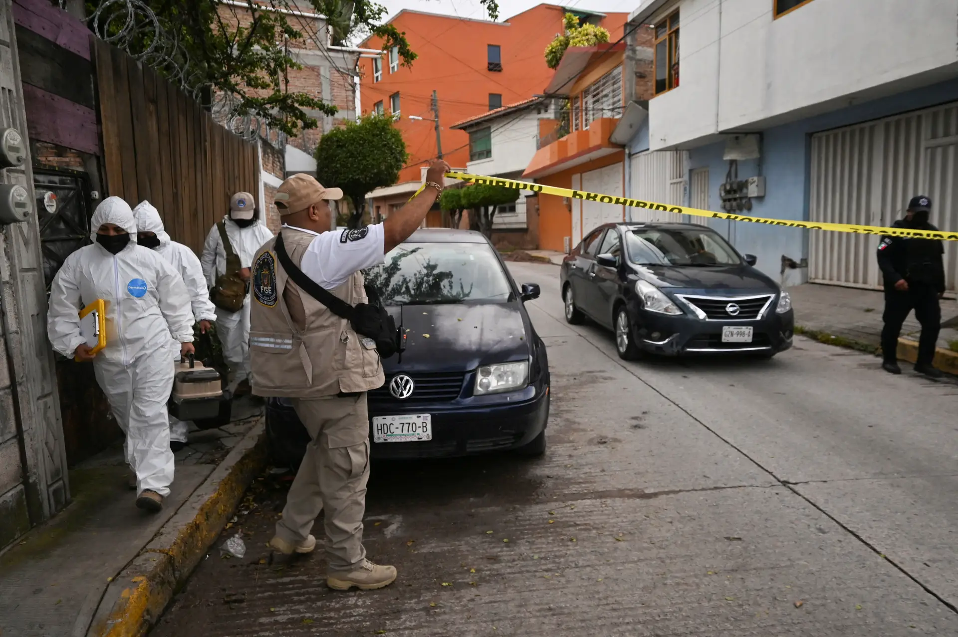 Membros de uma equipa forense caminham perto da cena de crime onde o jornalista Fredid Román foi morto no seu carro por atacantes armados em Chilpancingo, México