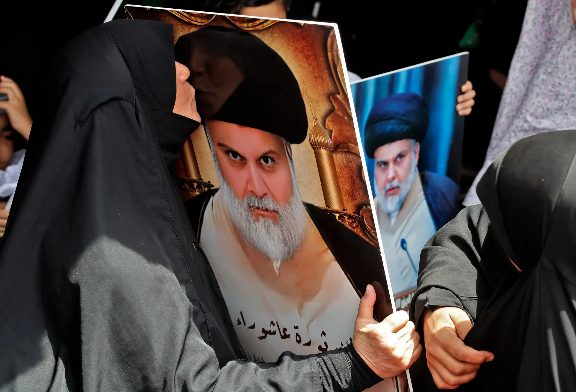 Uma iraquiana beija o retrato do clérigo xiita Muqtada al-Sadr, numa vigília no exterior do edifício do Parlamento, em Bagdade