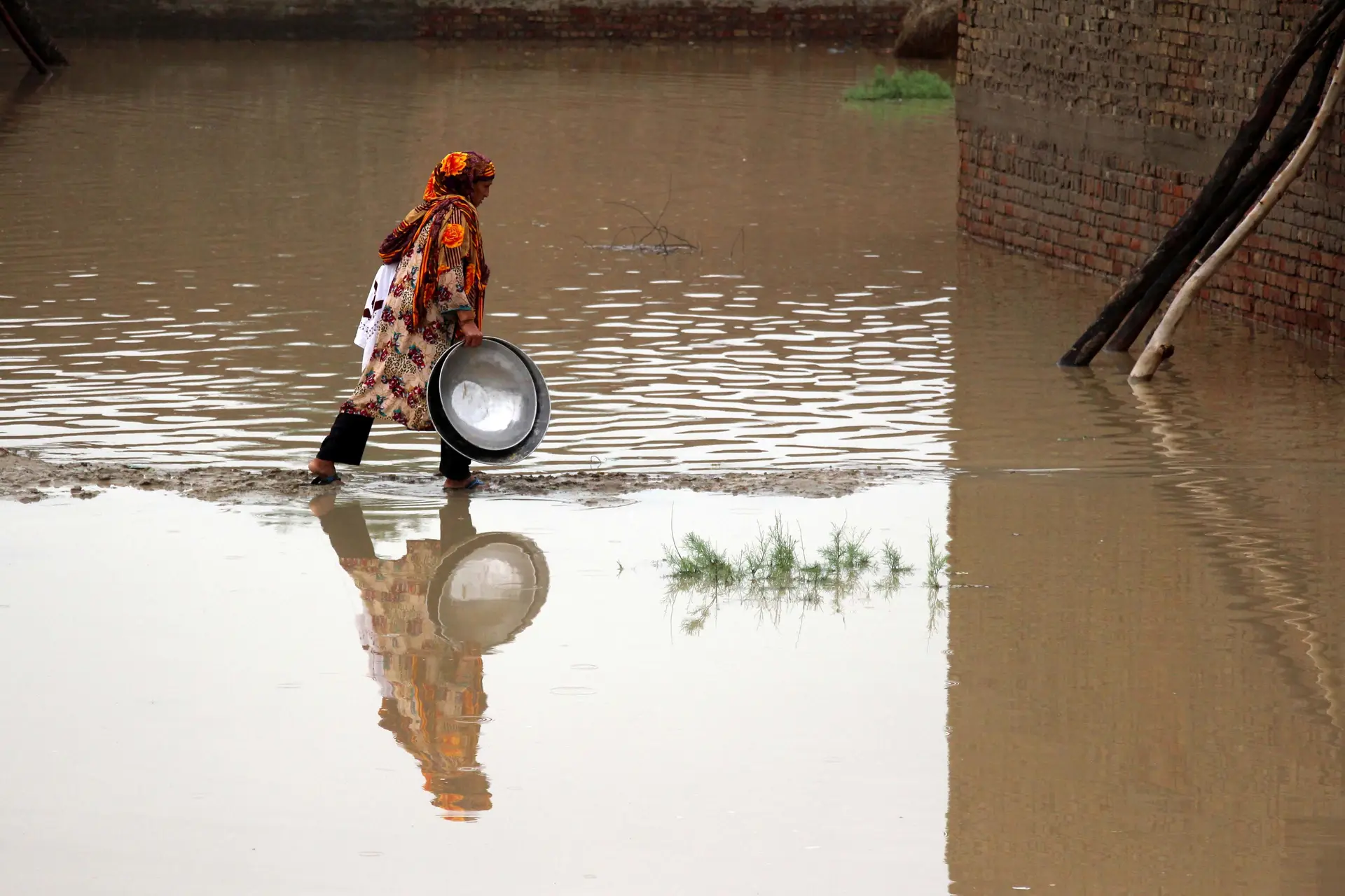 Uma mulher percorre uma zona inundada, a 22 de agosto. Várias aldeias ficaram submersas e 150 pessoas tiveram de ser retiradas na quinta-feira no distrito de Dadu