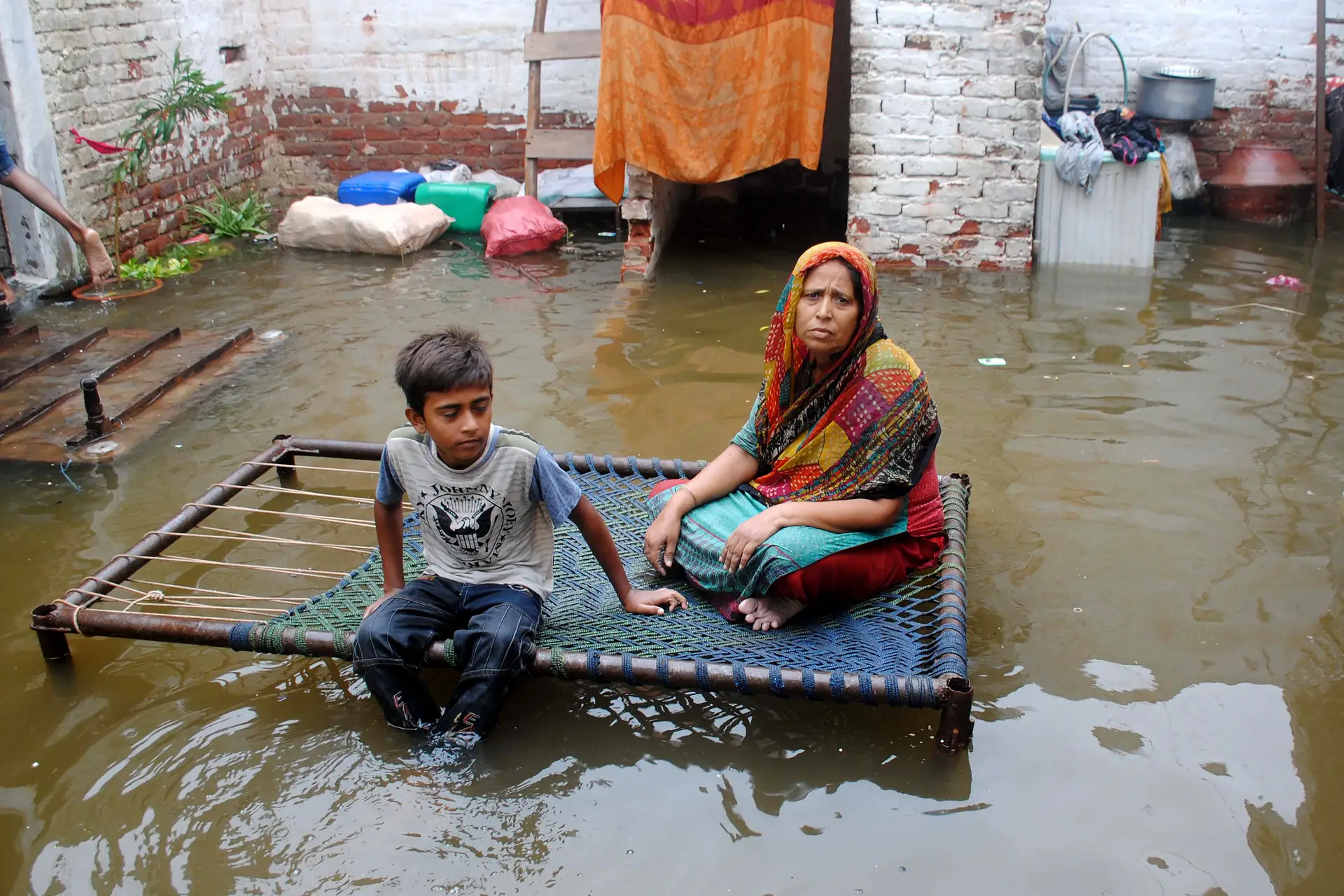 Uma mulher e um rapaz esperam por auxílio em Hyderabad. A maioria dos danos causados pelas inundações foi nas províncias de Sindh e Balochistão