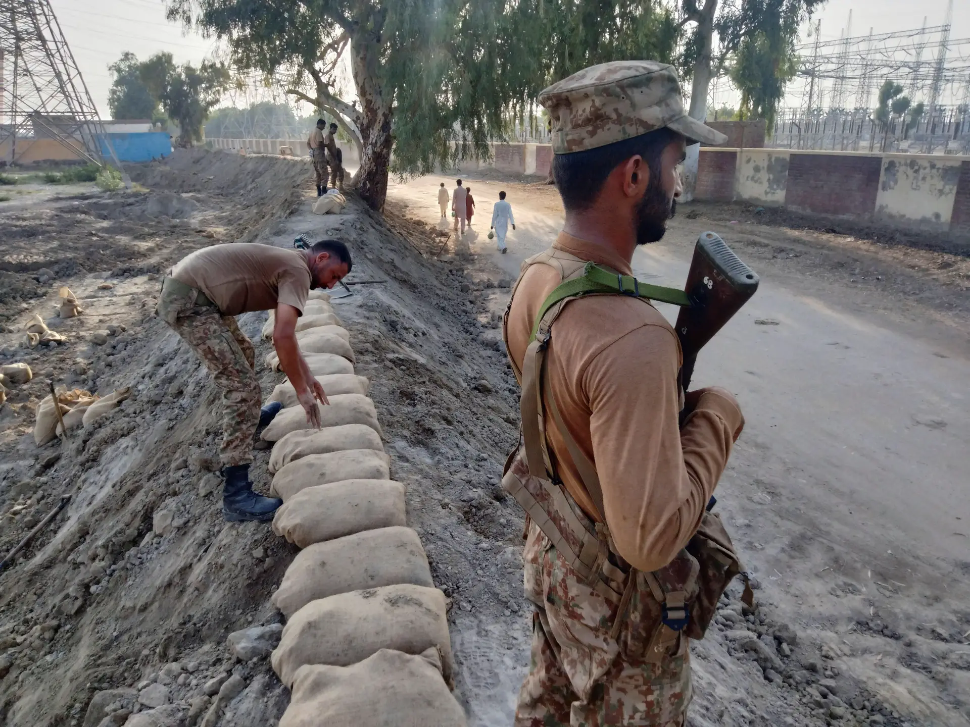 Perante a ameaça de novas cheias, militares erguem uma barreira de proteção, junto a uma importante central elétrica, em Dadu