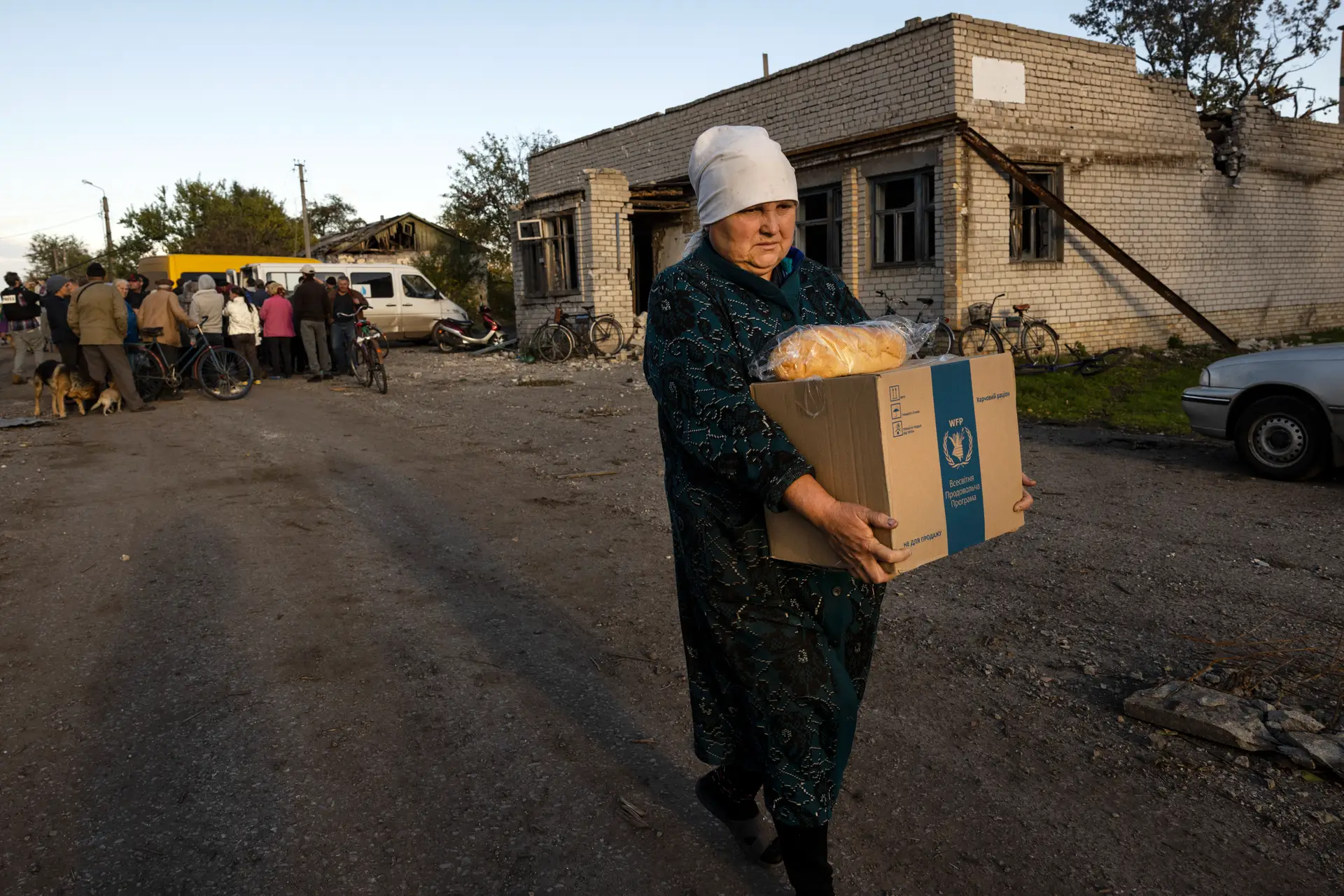 Uma senhora carrega ajuda humanitária fornecida pelo World Food Program, perto da cidade de Lyman, libertada pelos ucranianos recentemente