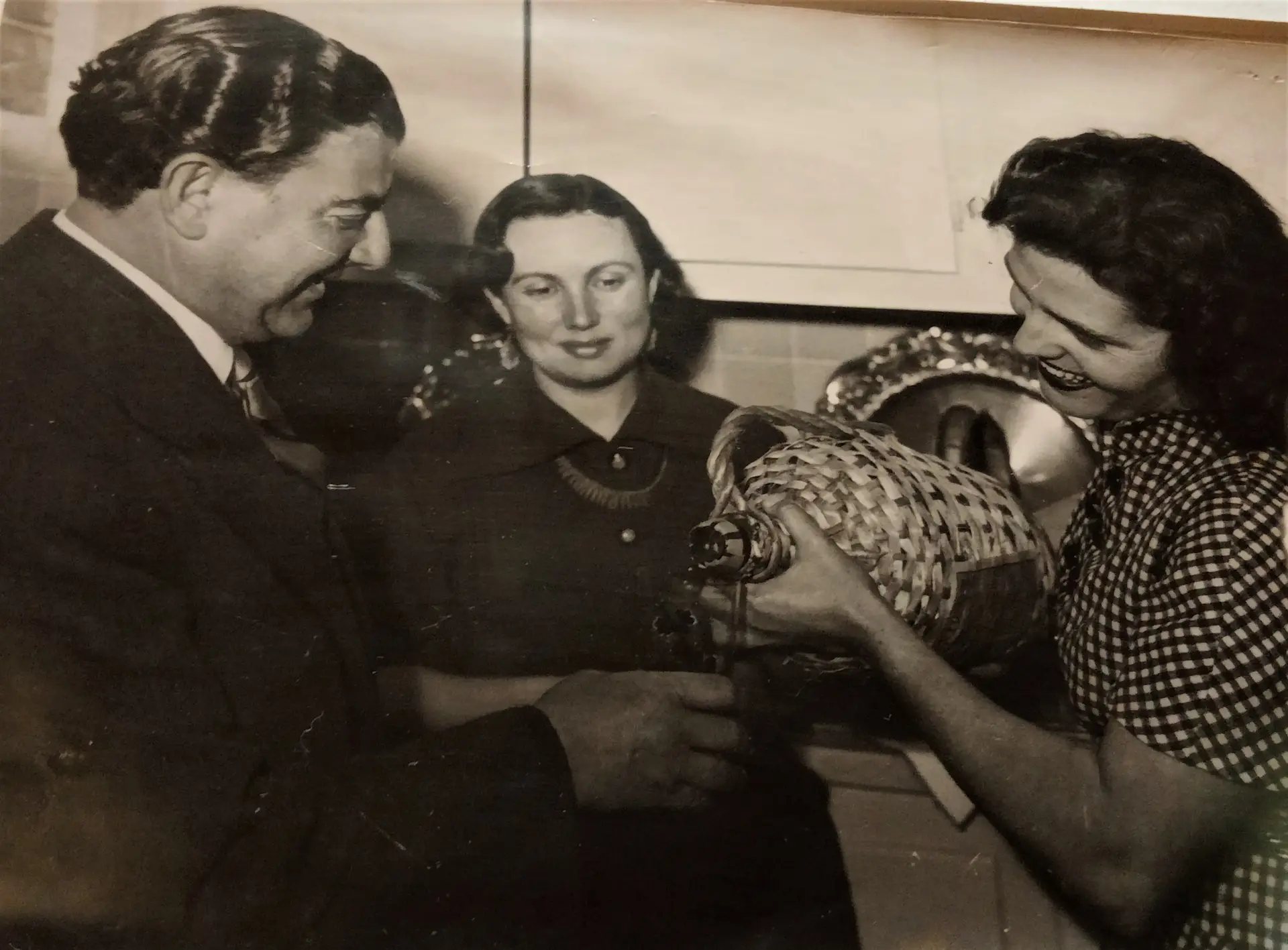 Amália segura um garrafão de vinho numa foto de arquivo com Armando e Maria de Lurdes Machado