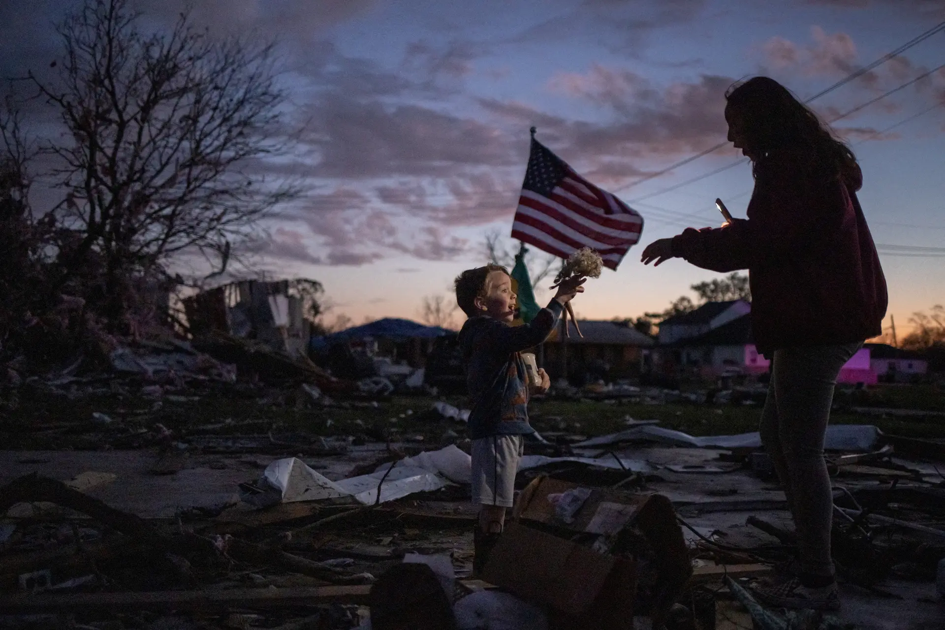 RECOMEÇO. Uma criança encontra uma boneca entre os destroços provocados pela passagem de um tornado, nos arredores de Nova Orleães