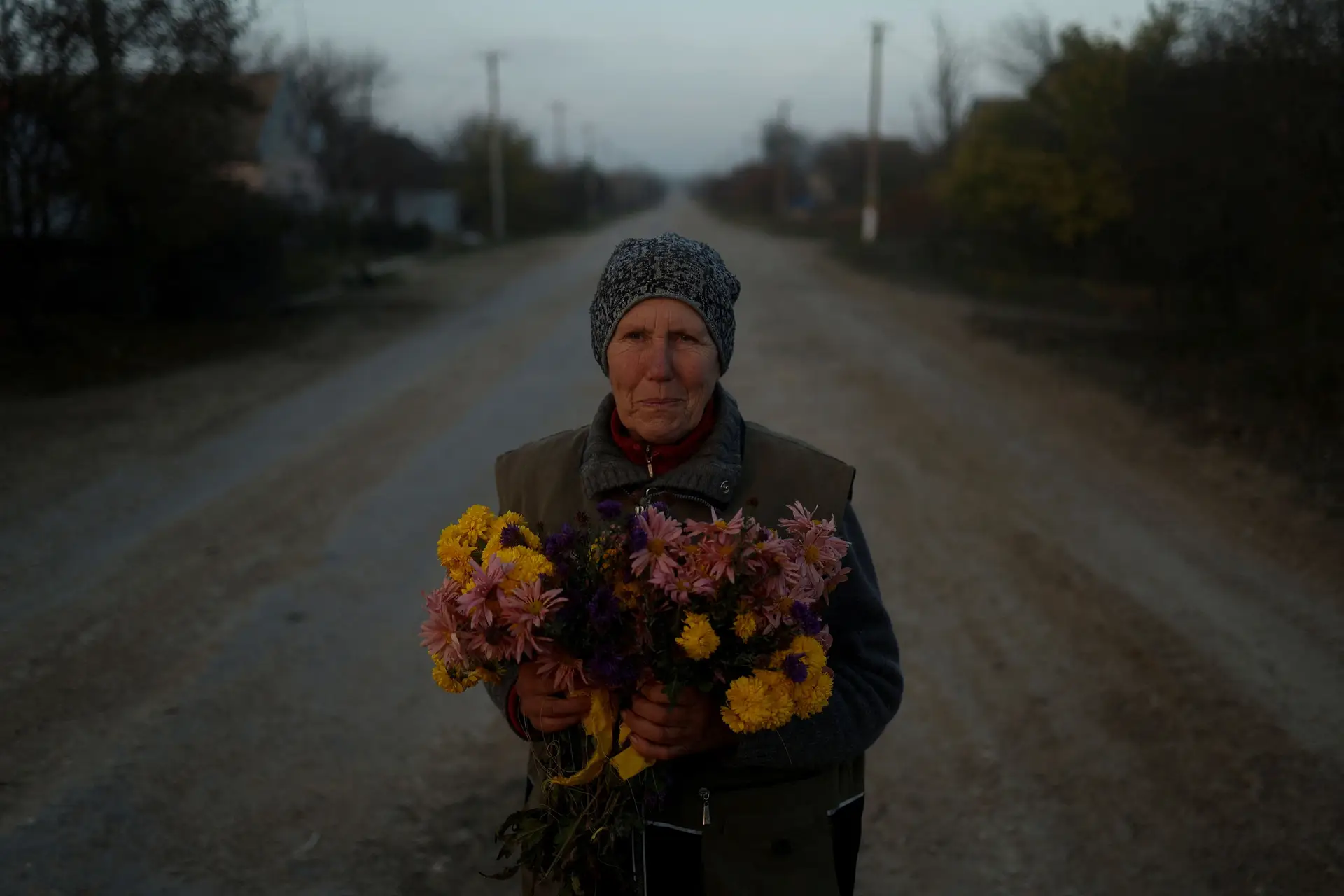 AGRADECIMENTO. Numa aldeia perto de Kherson, resgatada aos russos, uma mulher leva flores para entregar aos militares ucranianos