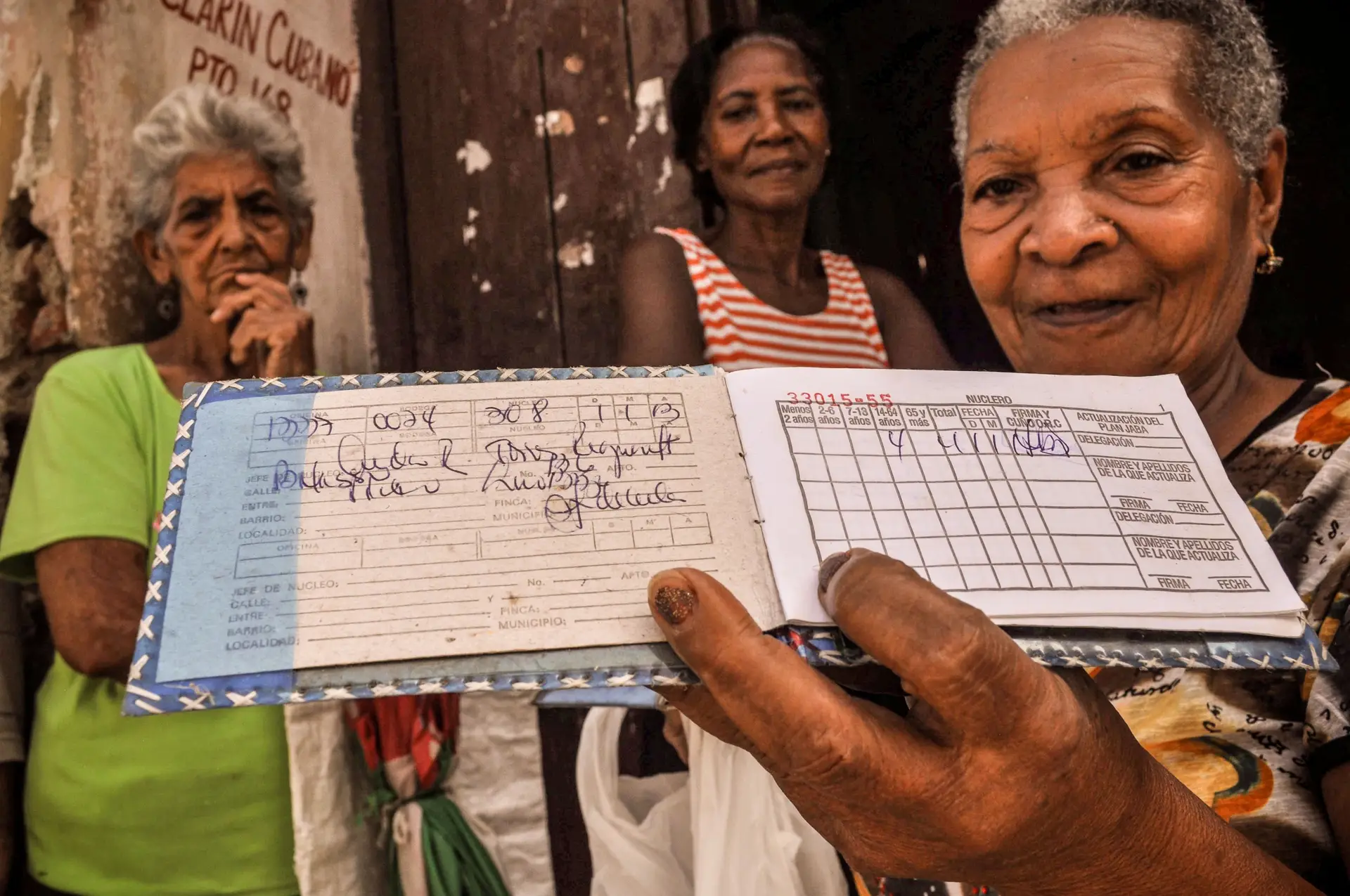 Uma cubana de Santiago de Cuba mostra a sua ‘libreta’, a caderneta de racionamento que lhe permite comprar mantimentos a baixos preços, graças aos subsídios do Estado