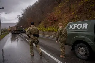 Militares da missão da NATO no Kosovo (KFOR) dirigem-se para um dos bloqueios rodoviários, no norte do território