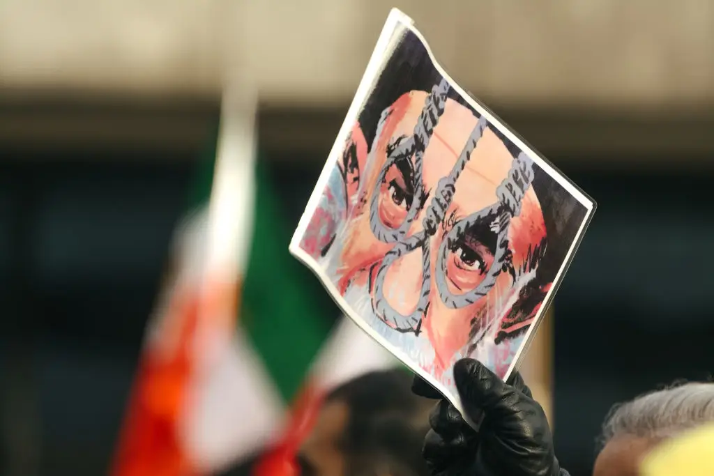 Três cordas usadas na execução de pessoas por enforcamento sobre a imagem do Líder Supremo do Irão, num protesto em Colónia, Alemanha