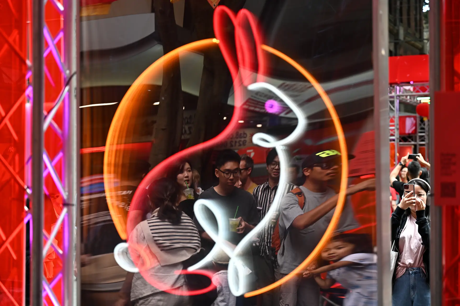 Pessoas refletidas num sinal em néon de um coelho, durante as celebrações do Ano Novo Lunar em Sydney, na Austrália. As comunidades chinesas celebrarão o Ano Novo Chinês a 22 de janeiro, data em que se iniciará o 'Ano do Coelho' no calendário.