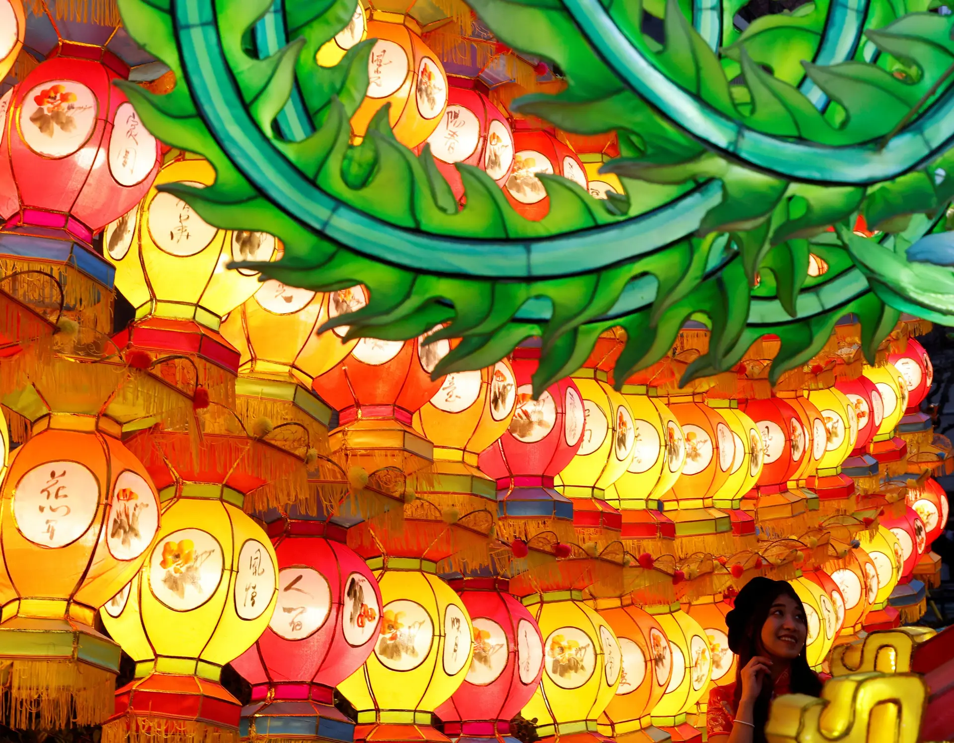 Uma mulher posa para a fotografia em frente à decoração de lanternas na véspera do Ano Novo Lunar, na Chinatown de Yokohama, Kanagawa, Japão