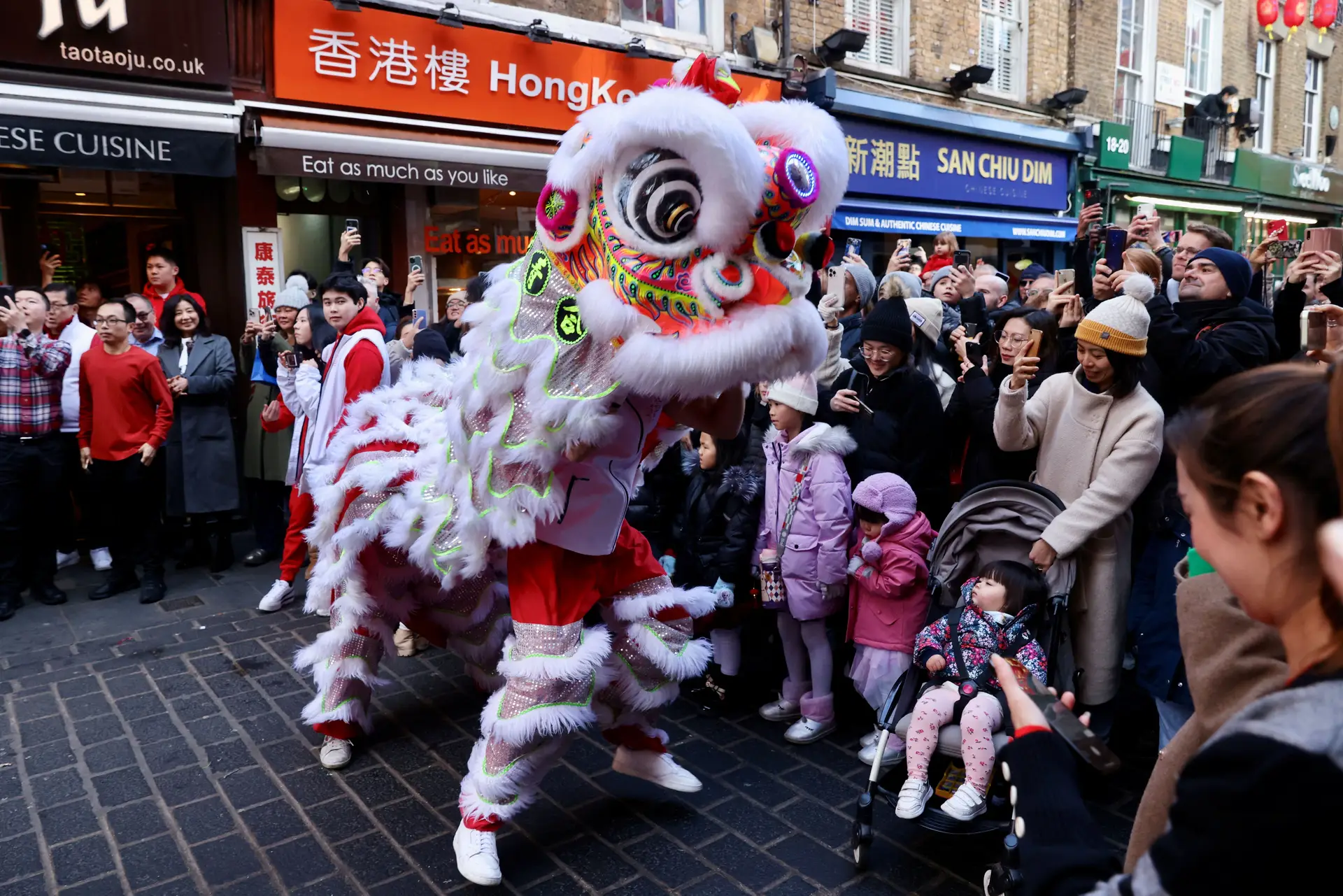A dança do leão chinês é realizada nas ruas da Chinatown londrina, em Inglaterra