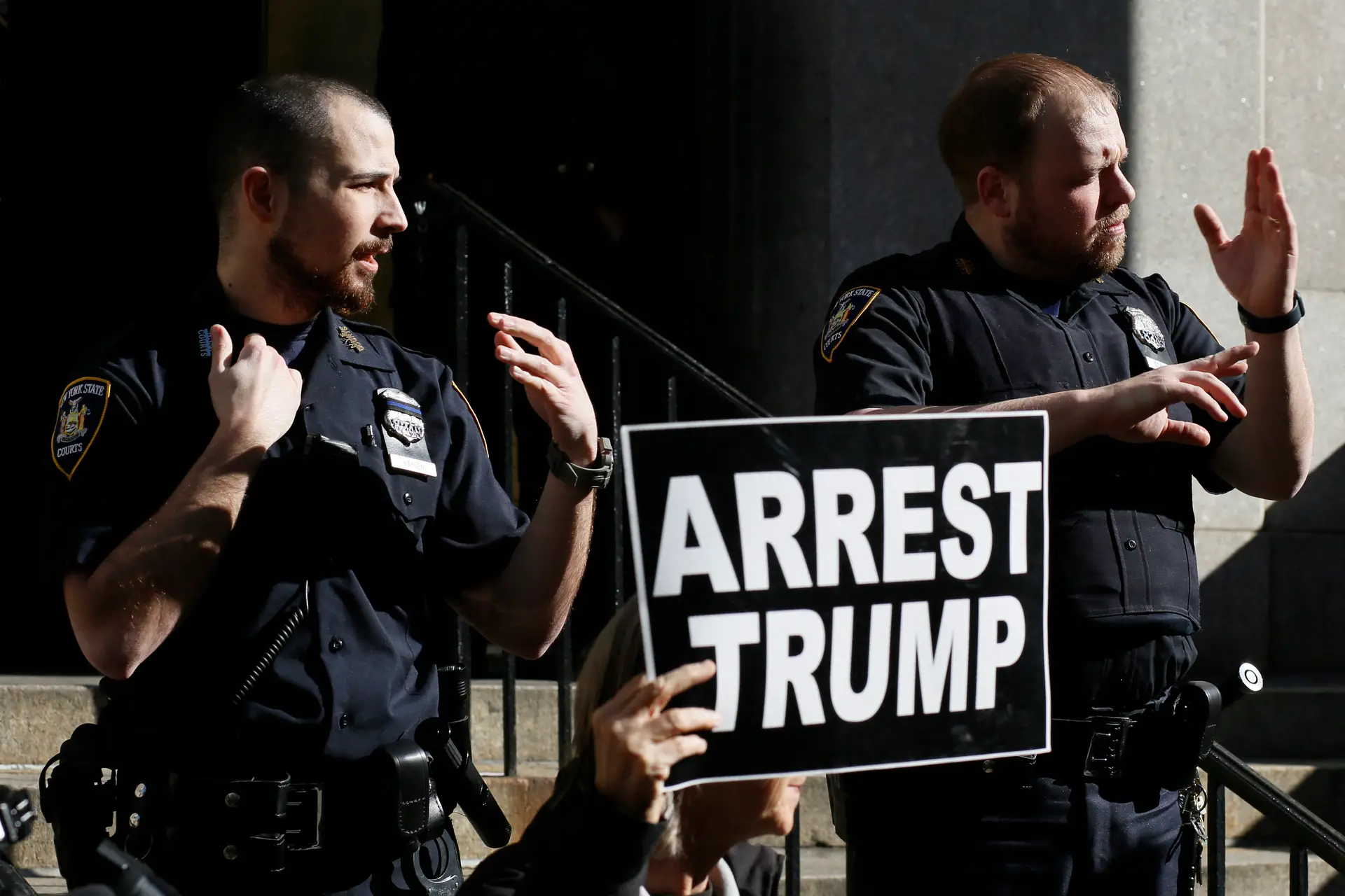 Manifestantes exibem um cartaz a reclamar a prisão de Trump, à porta da procuradoria-geral de Nova Iorque, a 20 de março de 2023 