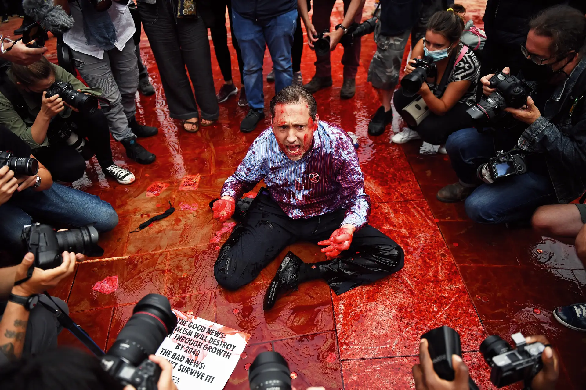 Manifestante do Extinction Rebellion coberto de sangue falso em Londres. Ameaça climática está a aumentar 