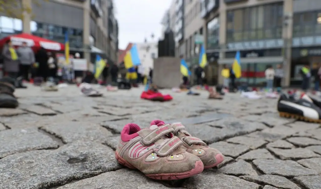 Botas de criança e bandeiras da Ucrânia, numa manifestação, este sábado, na cidade alemã de Jena (estado de Turíngia)