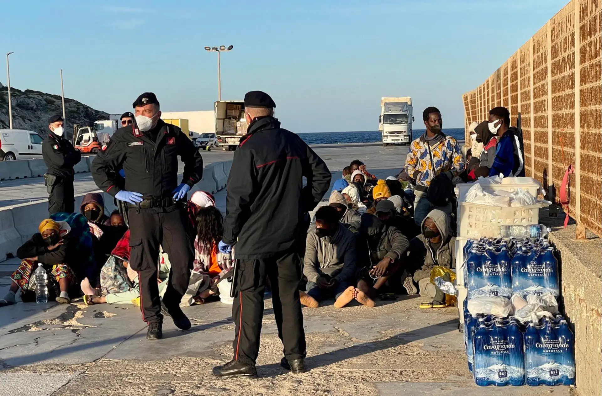 Migrantes à espera do ferry que os levará para a Europa continental, em Lampedusa