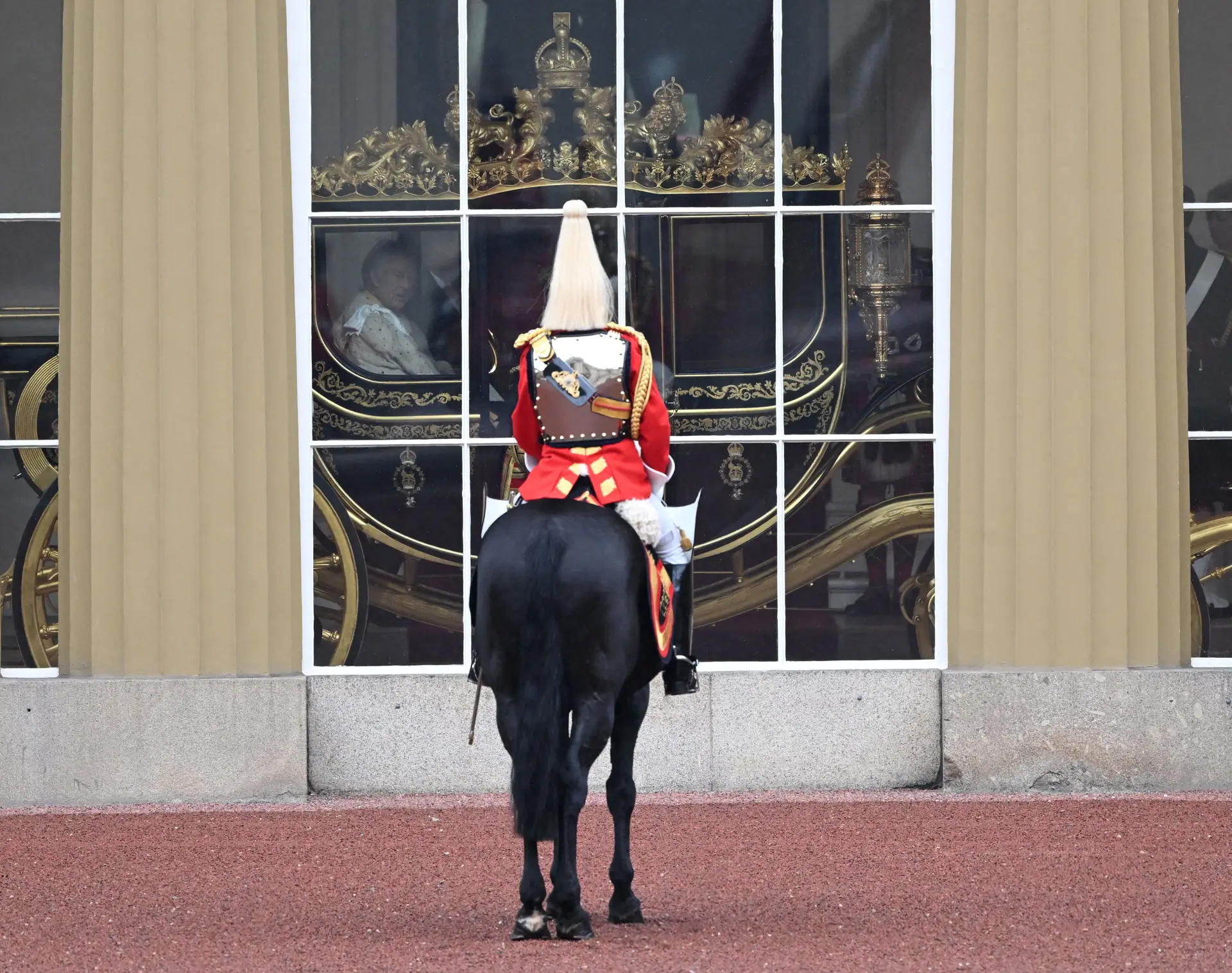 Membro da cavalaria britânica aguarda a saída de Carlos III e de Camila do Palácio de Buckingham para a Abadia de Westminster. 