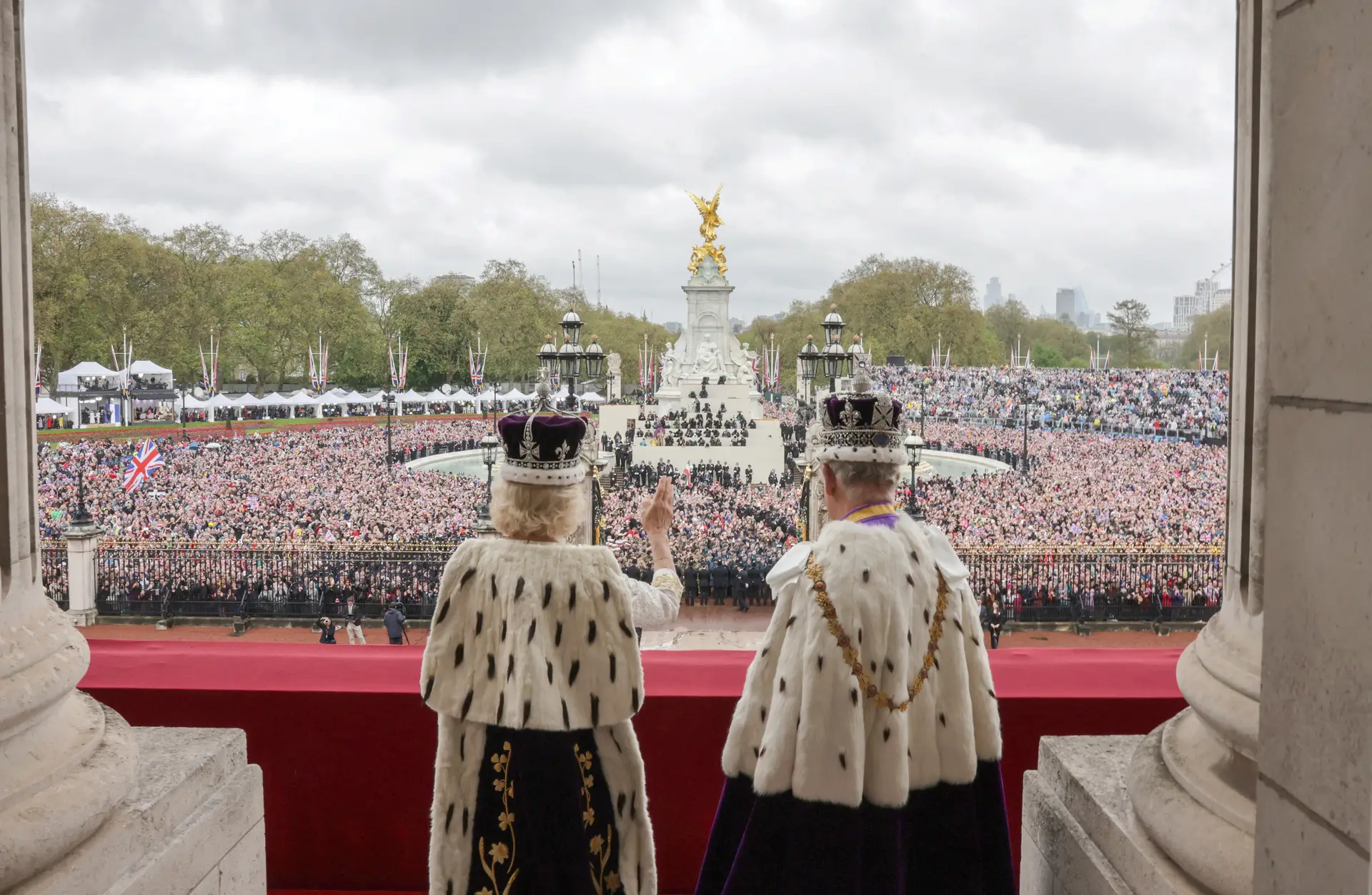 A rainha Camila e o rei Carlos III na varanda do Palácio de Buckingham, perante milhares de pessoas que encheram as ruas de Londres