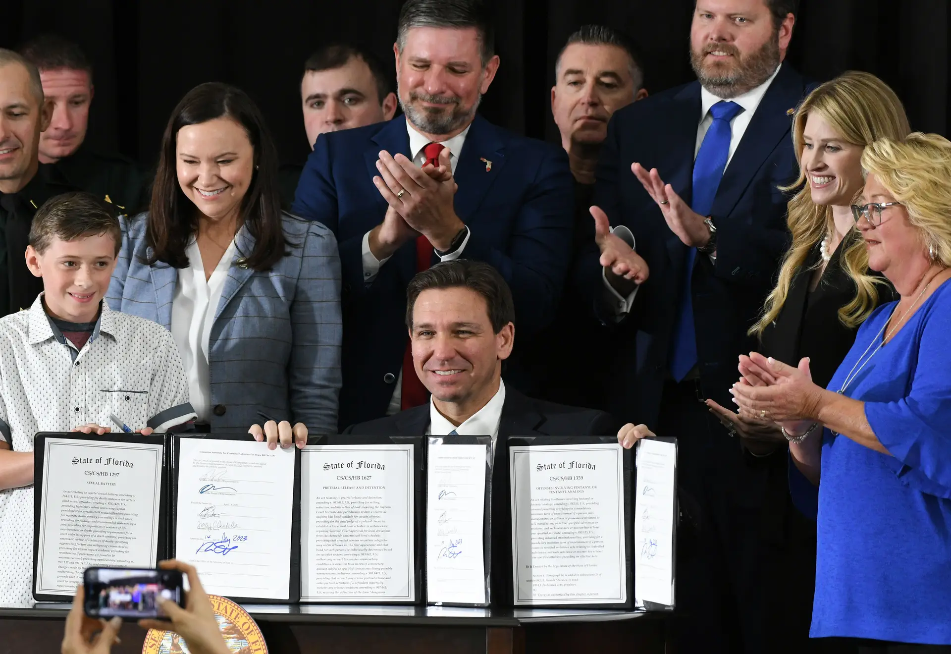 Ron DeSantis exibindo leis que promulgou enquanto governador da Florida